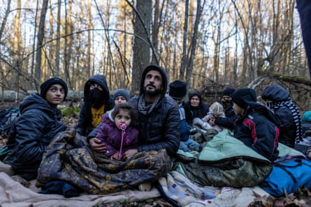 Members of a Kurdish family from Dohuk in Iraq are seen in a forest near the Polish-Belarus border while waiting for the border guard patrol, near Narewka, Poland, on November 9, 2021.