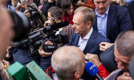 Polish opposition leader, former premier and head of the centrist Civic Coalition bloc, Donald Tusk is seen surrounded by press and supporters as he arrives at a polling station in Warsaw, Poland on October 15, 2023, during the country's parliamentary elections.
