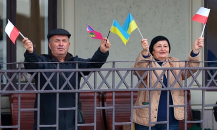 A man and woman wave miniature flags of Ukraine and Poland at the Rava-Ruska station during the launch of train route connecting Lviv and Warsaw at the weekend.