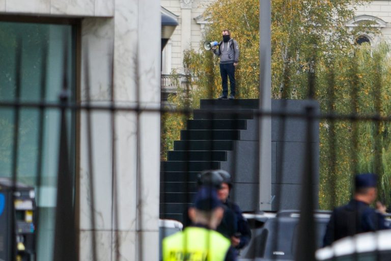 Police in Warsaw seal off a large square after a man climbs a monument and reportedly makes threats