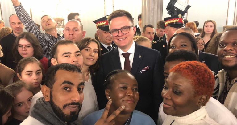 Polish speaker faces criticism for posing with Belarus border crossers in parliament