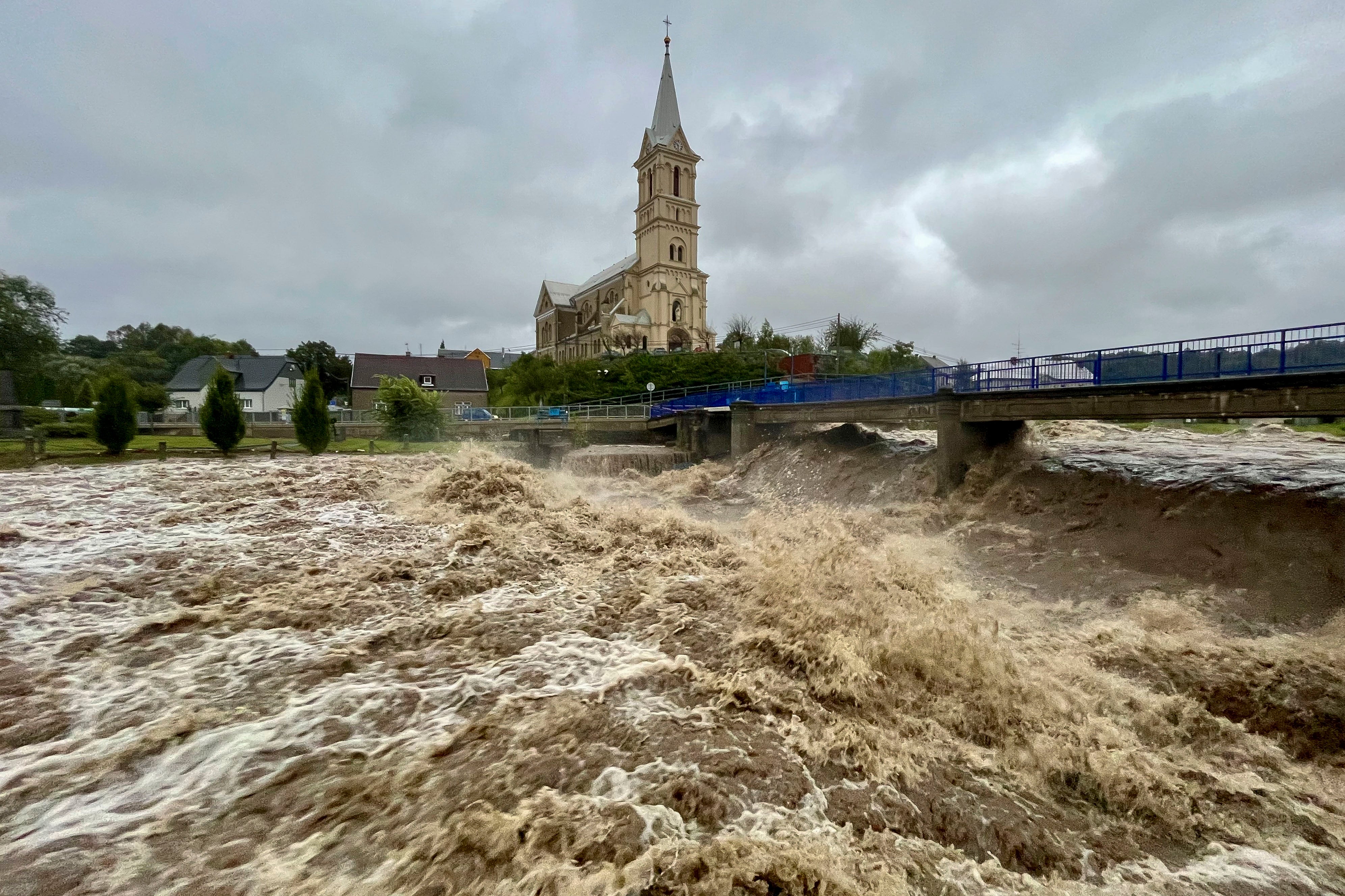 A torrent of water flows along the river Bela during heavy rain