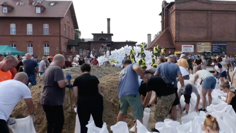 Volunteers in human chain to distribute sandbags during Poland floods | News